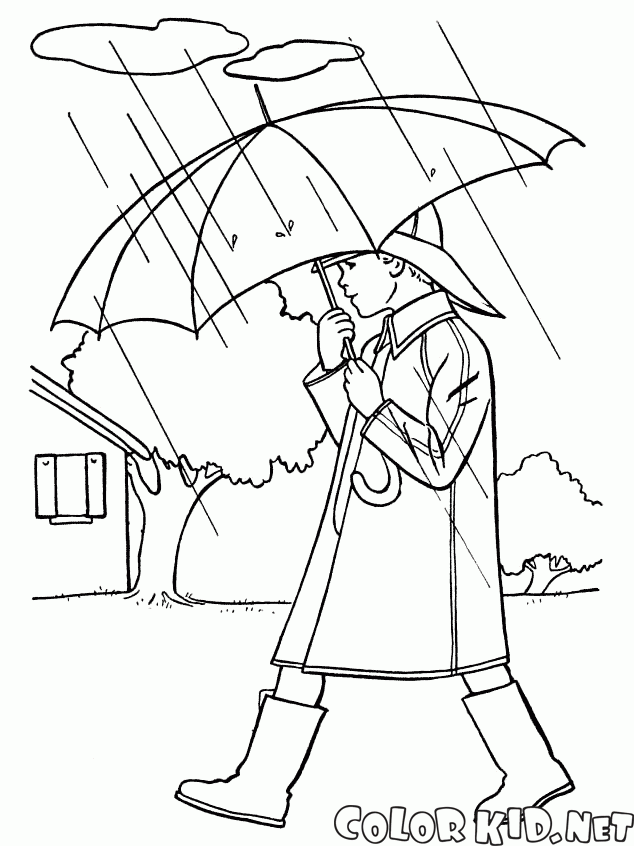 Le garçon se promène sous la pluie