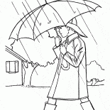 Le garçon se promène sous la pluie